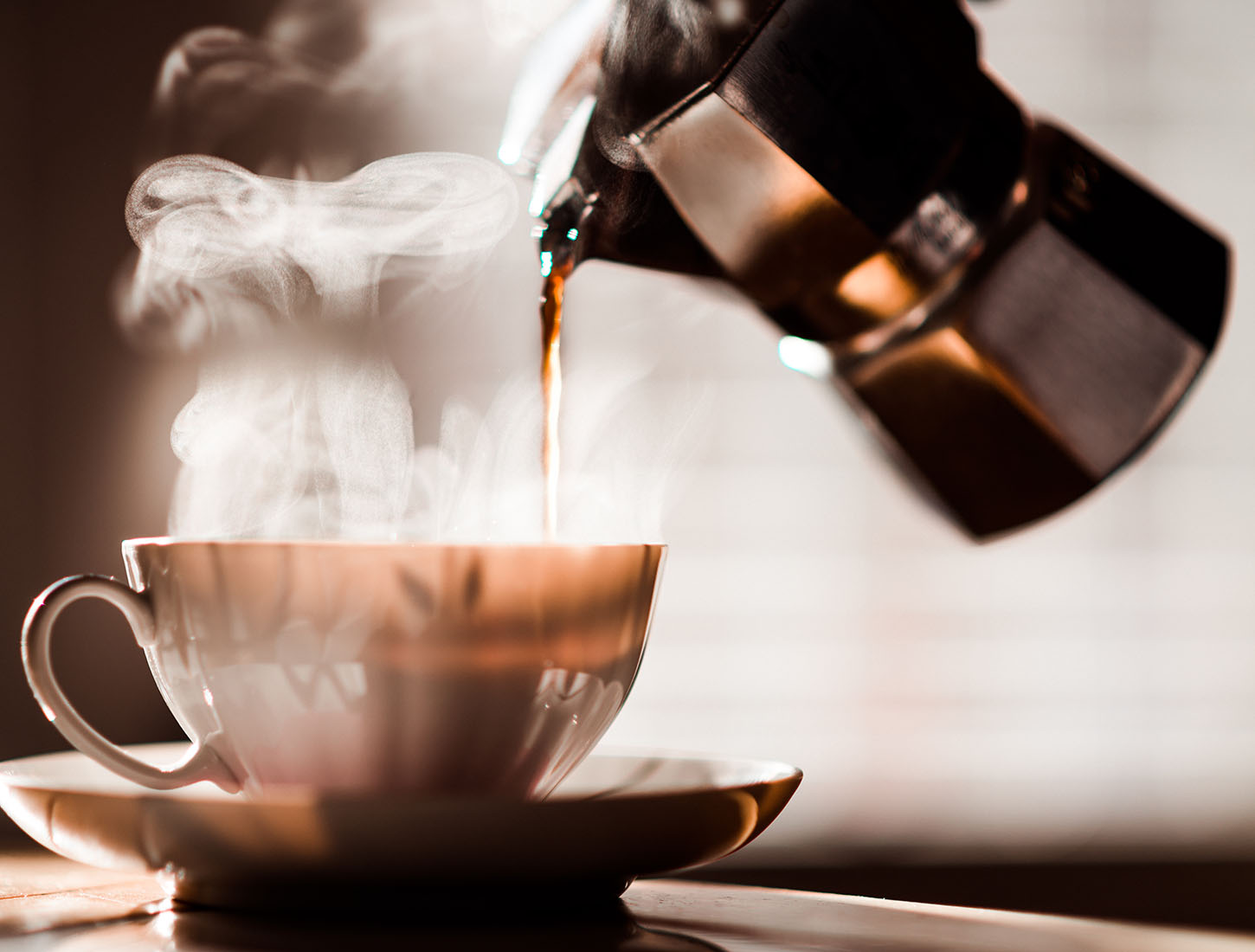湯気の立つカップに注がれるコーヒー